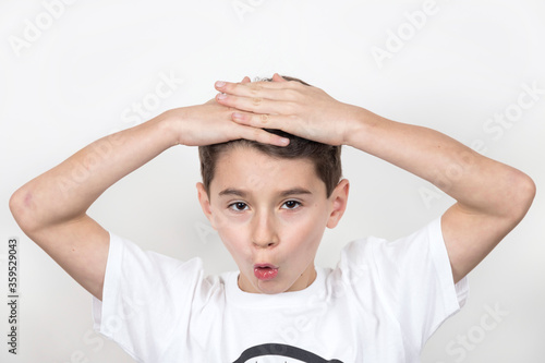 Teenage boy in white shirt. Portrait in studio. Funny faces.