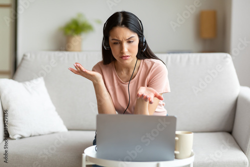 Displeased Woman Making Video Call Using Laptop Sitting At Home