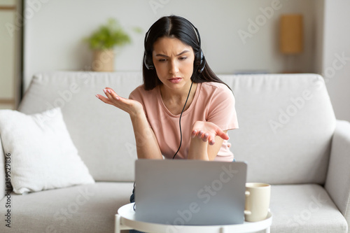 Картината върху платно Displeased Woman Making Video Call Using Laptop Sitting At Home