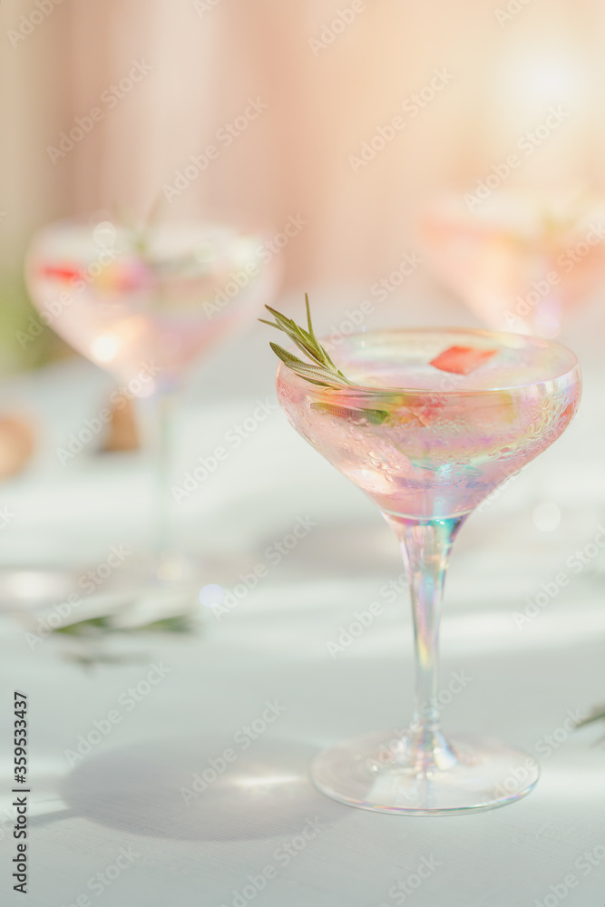 Glass of strawberry cocktail or mocktail, refreshing summer drink with crushed ice and sparkling water on light blue background.