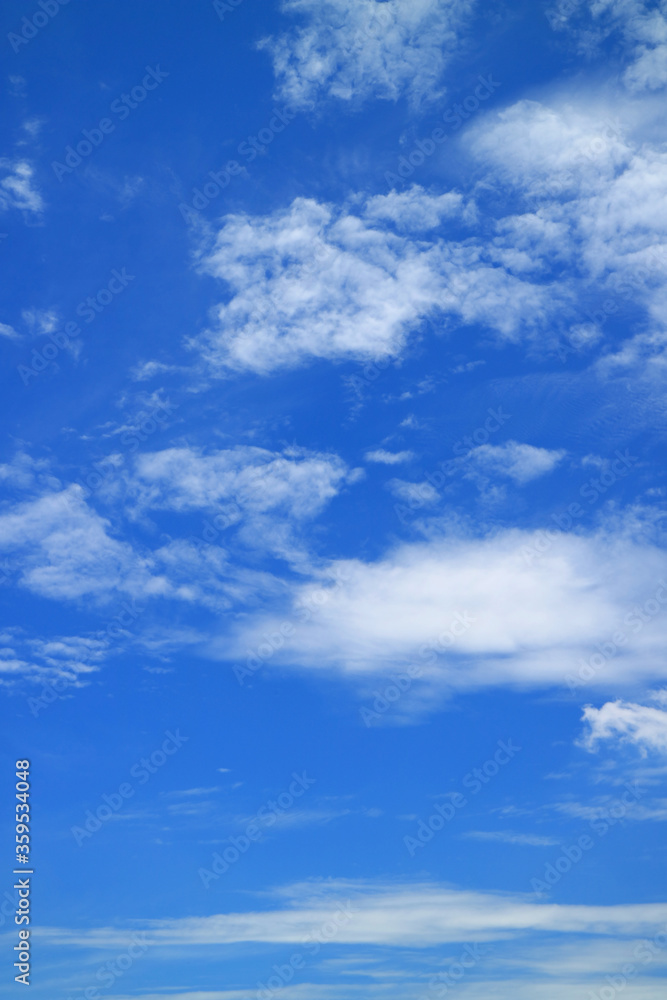 Vertical image of vivid blue sky with pure white clouds