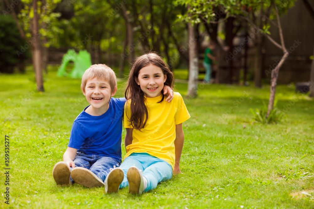 The little brother and sister have fun relaxing in the backyard The little brother and sister have fun relaxing in the backyard