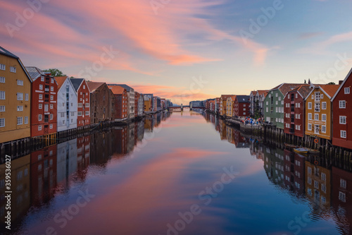 TRONDHEIM, NORWAY, july 2019: Sunrise view of colorful timber houses surrounding river Nidelva in the Brygge district of Trondheim, Norway