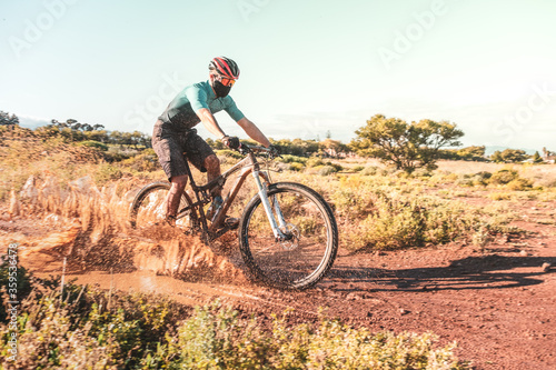 mountain biker riding through a muddy puddle