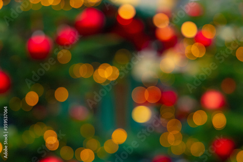 Christmas holidays festive garland illumination bokeh light red yellow lamps and green unfocused foliage wallpaper advertising pattern with empty copy space for your text