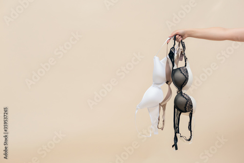 Woman is holding a bra in her hand. Brassiere choice. photo