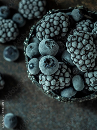 Frozen blackberry and blueberry berries, closeup, copy space.