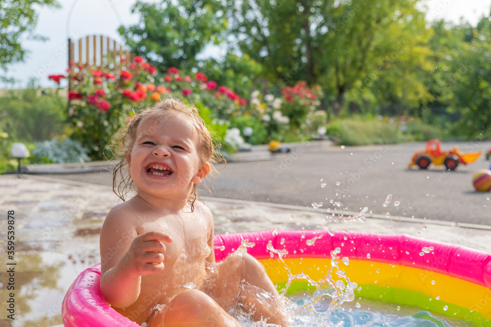 cute little girl swimming in a children's pool happy smiling. space for text cute little girl swimming in a children's pool happy smiling. space for text