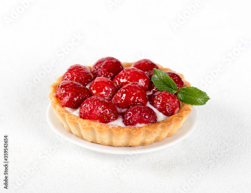 Tartlet with custard and strawberries on a white background