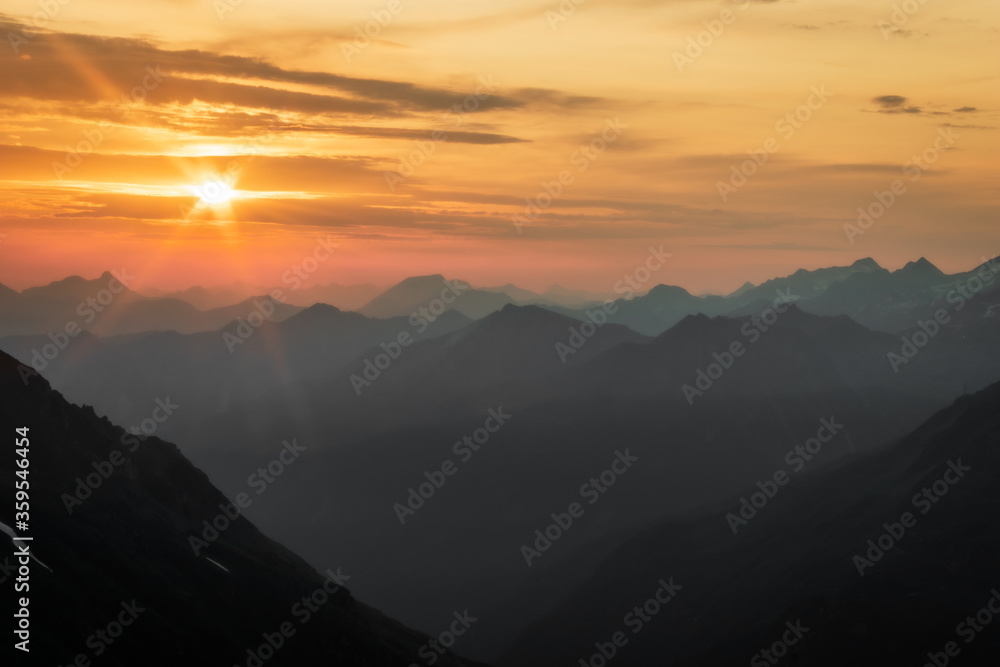 misty magical early morning sunrise over the summer mountain panorama in the Austrian Alps 
