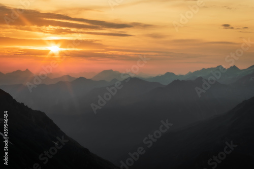 misty magical early morning sunrise over the summer mountain panorama in the Austrian Alps 