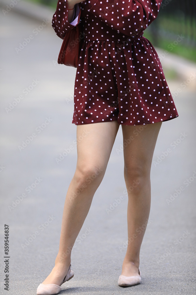 beautiful legs of a girl in burgundy shorts