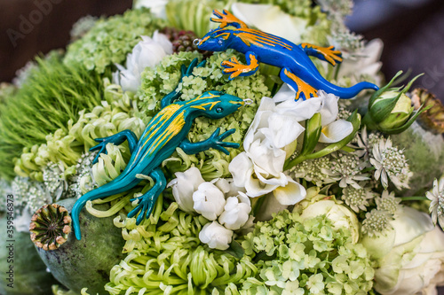  Artificial lizards on the background of a bouquet close-up.