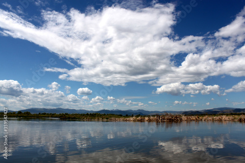 Lake scene in Montana with reflections of dynamic blue skies with clouds