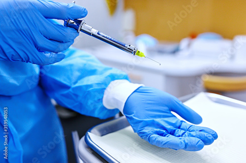 Doctor with syringe. Dental anaesthesia.  hands in blue protective gloves with anaesthesia syringe.  