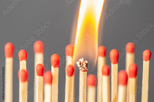 Burning match among many matches as symbol of infected person