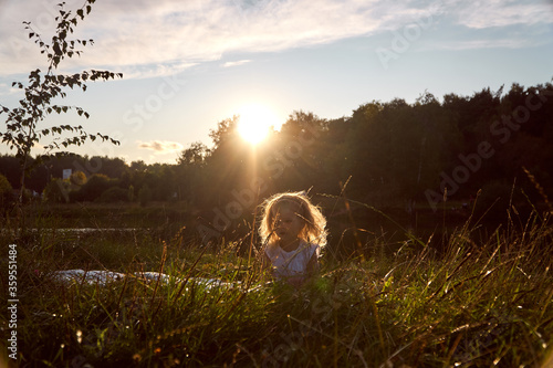 Happy child at sunset near the trees and lake. Happy childhood. The joy of kids. High quality photo