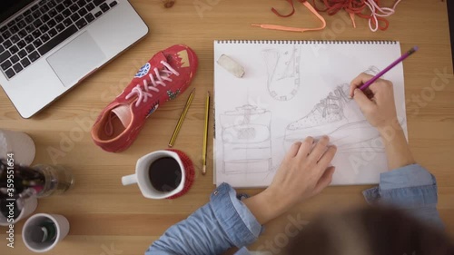 Top desk view of designer working on customizing sneakers sketch photo