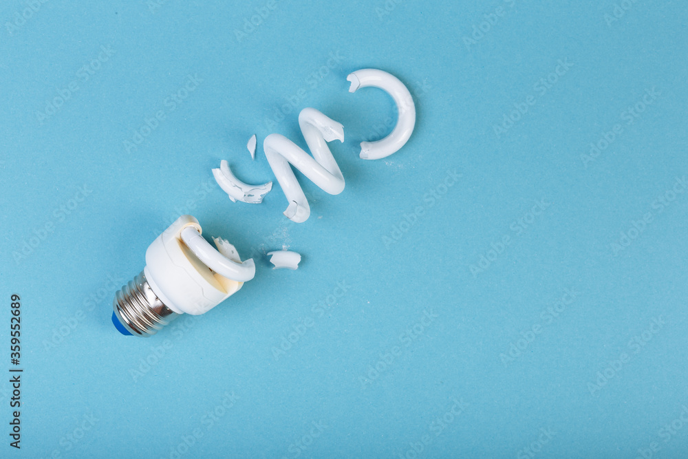 Concept of ecology pollution broken fluorescent spiral tube lamp