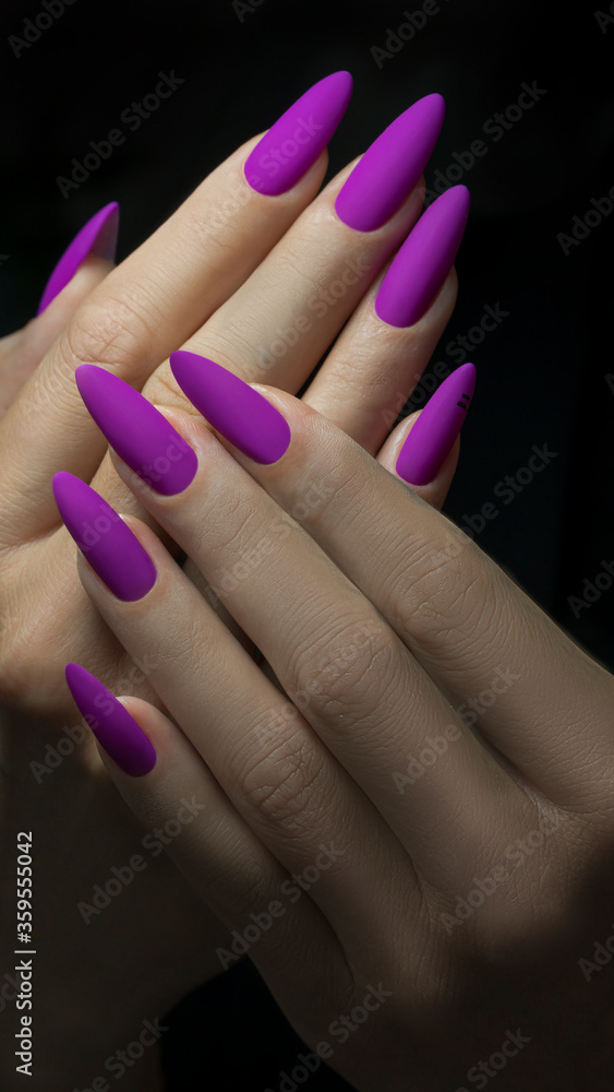 Fototapeta premium Art Manicure. Modern style violet Nails Polish. Violet long Nails on black background