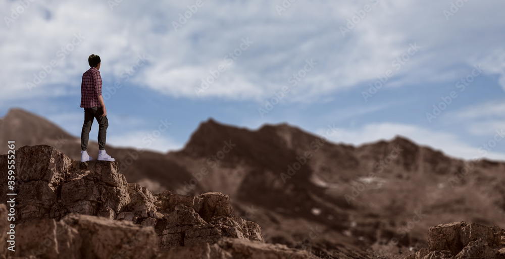 a boy hiker stand on rocky outcrop mountains peak.
