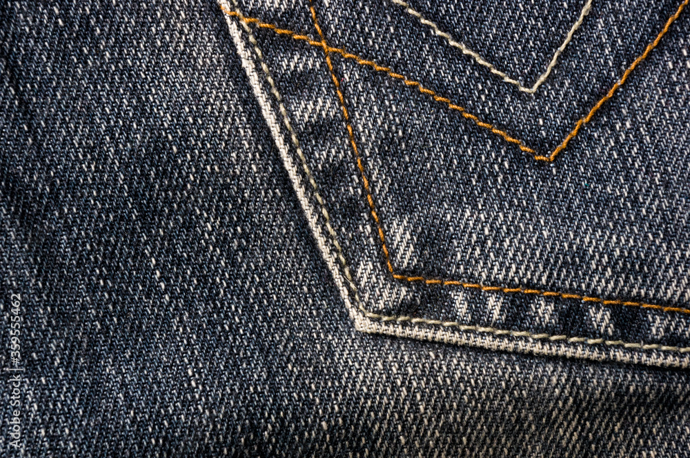 clothing items blue stonewashed faded jeans cotton fabric texture with seams, clasps, buttons and rivets, macro, close-up