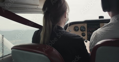 Woman with face mask pilot learn flying flight instructions small airplane plane sport aircraft during virus covid 19 coronavirus pandemic outbreak over shoulder close up