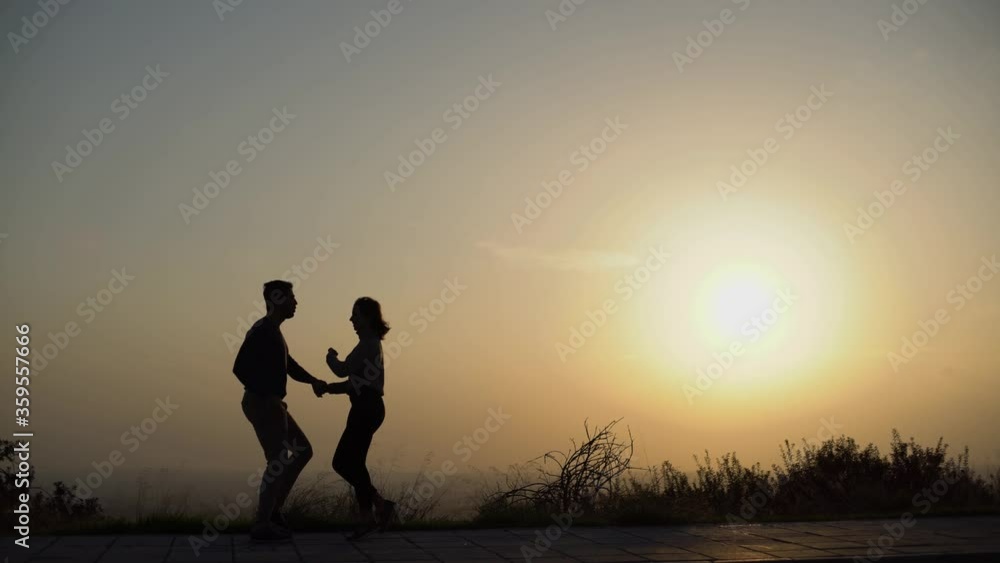 Silhouettes of young dancers practising Latin salsa and rumba outdoors Silhouettes of young dancers practising Latin salsa and rumba outdoors