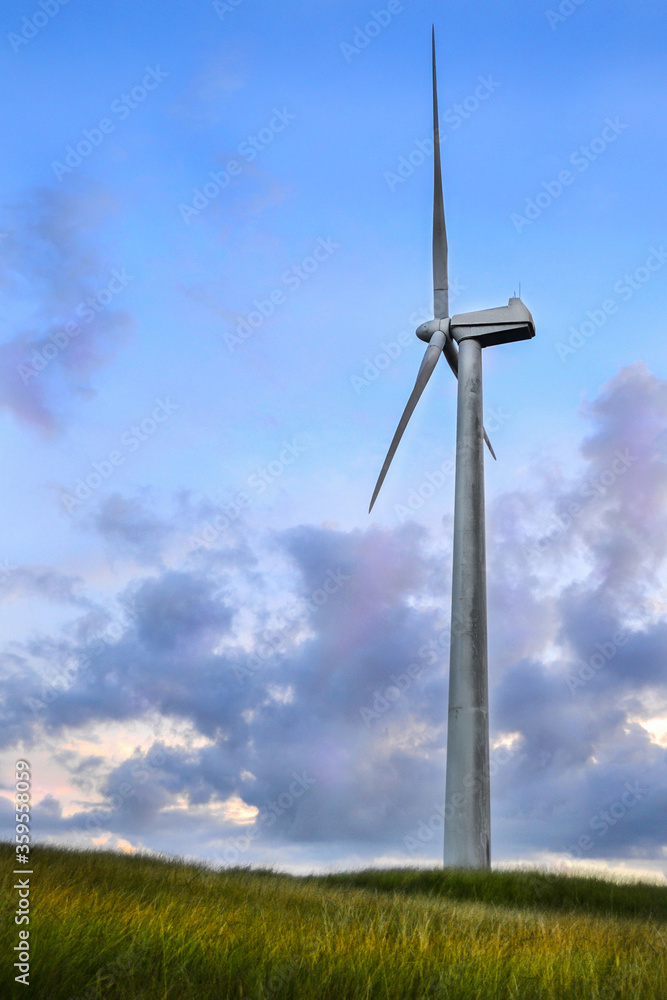 Renewable energy wind turbine with bright sunset colors in background Renewable energy wind turbine with bright sunset colors in background
