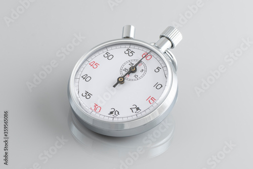 Analogue metal stopwatch on the gray background.