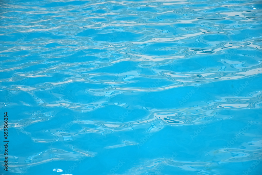Soft waves in swimming pool. Background and texture of natural crystal clean water.