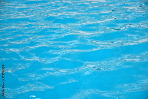 Soft waves in swimming pool. Background and texture of natural crystal clean water.