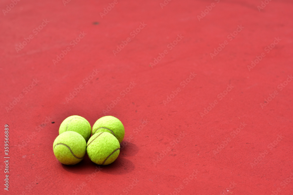 Closeup of Tennis Racket and balls on Tennis Courts in the outdoors.