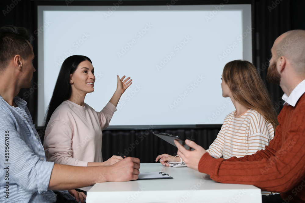 Business people having meeting in conference room with video projection screen Business people having meeting in conference room with video projection screen