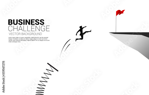 Silhouette of businessman jump to red flag on cliff with springboard. Concept of boost and growth in business.