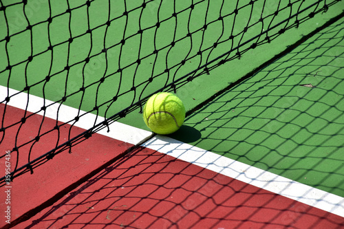 Closeup of Tennis Racket and balls on Tennis Courts in the outdoors. © masterjew