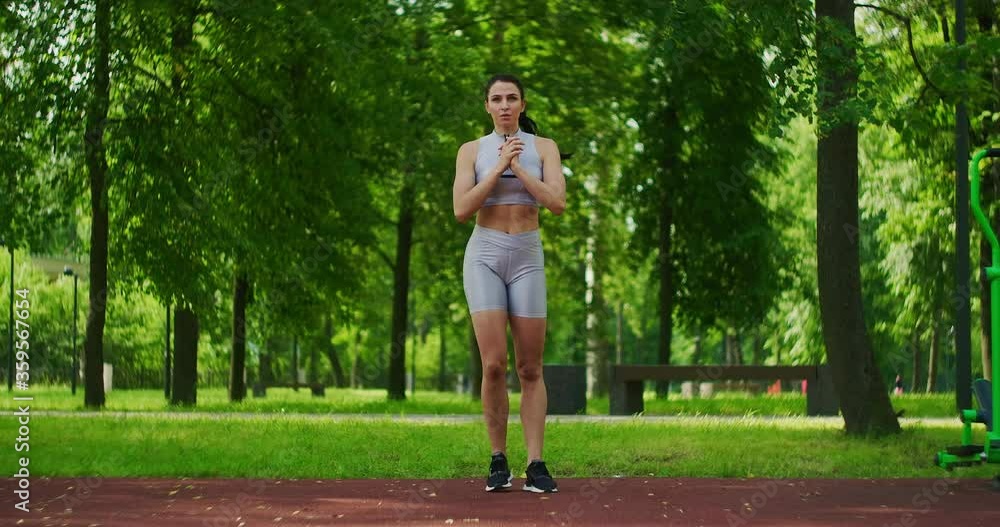Female athlete performs side lunges work out her legs in the Park in slow motion. Beautiful woman playing sports in the Park. Female athlete performs side lunges work out her legs in the Park in slow motion. Beautiful woman playing sports in the Park.