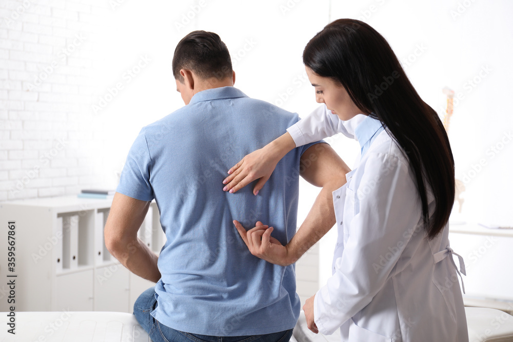 Professional orthopedist examining man in medical office Professional orthopedist examining man in medical office