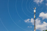 High metal pole with mobile communications equipment on a background of blue sky in white clouds. Radio waves diverge from the top of the pillar