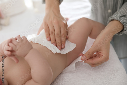 Mother changing her baby s diaper on table  closeup