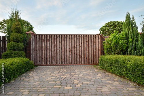 Obraz na plátně Grunge wooden entrance gate to the mansion with a pavement