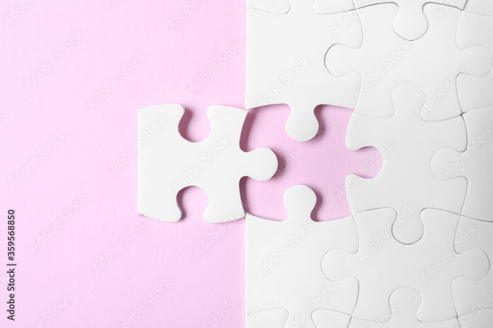 White puzzle with separated piece on pink background, flat lay White puzzle with separated piece on pink background, flat lay