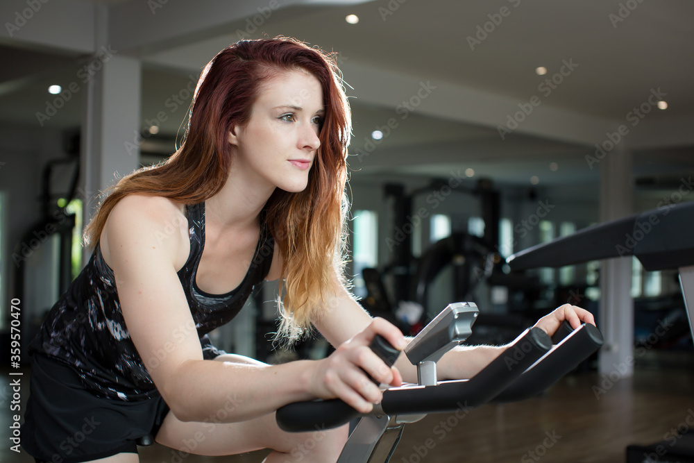 woman sport biking in the gym for fitness woman sport biking in the gym for fitness