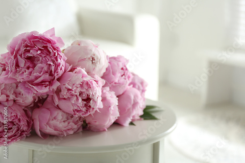 Bunch of beautiful peonies on table indoors. Space for text