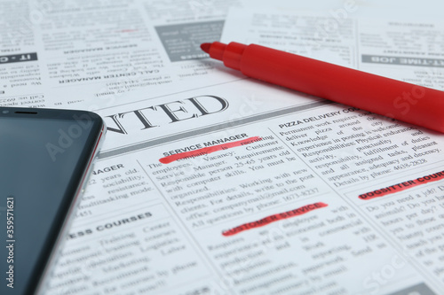 Smartphone and marker on newspaper. Job search concept