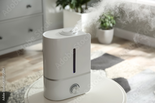 Modern air humidifier on table at home photo