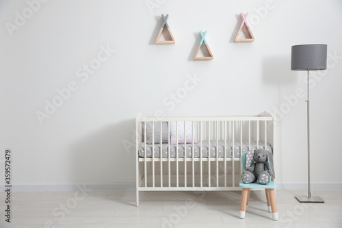 Cute baby room interior with modern crib photo