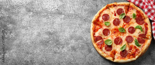 Top view of hot delicious pizza on grey table, space for text. Banner design