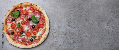 Top view of hot delicious pizza on grey table, space for text. Banner design