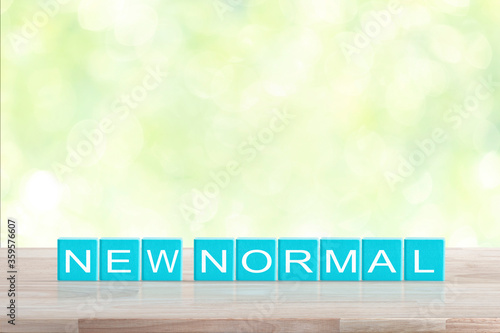 NEW NORMAL word on wooden cube. New normal background.  New normal after covid-19 pandemic with social distancing, good hygiene